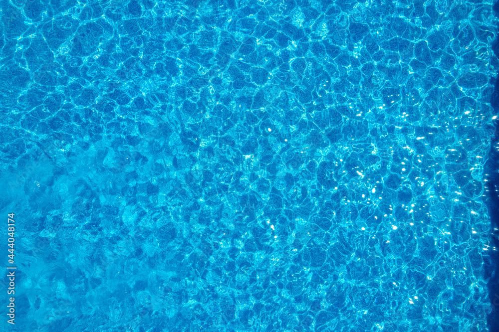 Turquoise pool background aerial top view. Blue water texture with fine ripples