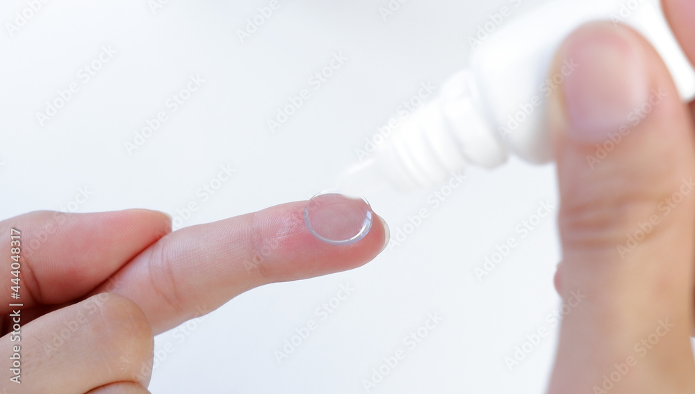 Contact lens on finger on a blue background
