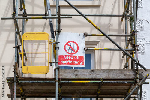 Scaffolding on the side of a building with a sign that reads Keep off scaffolding