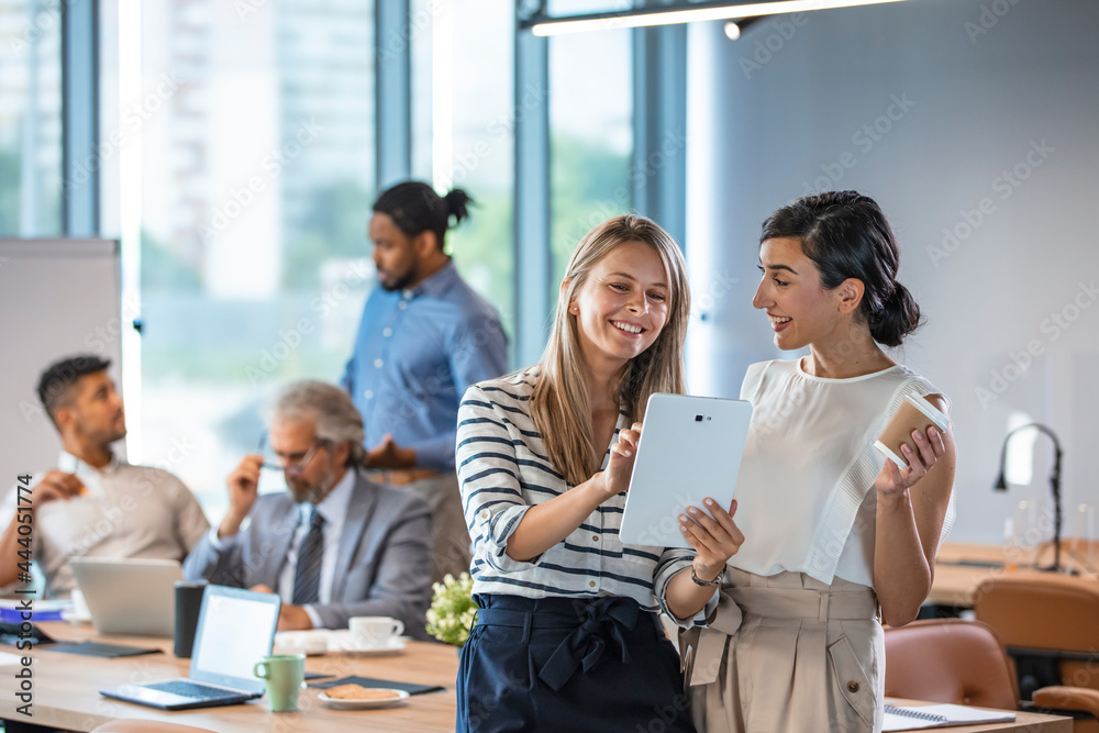 Shot of two businesswomen discussing something on a digital tablet. Business colleagues having a conversation. They are both young business people casually dressed in a modern office. Shot of two businesswomen discussing something on a digital tablet. Business colleagues having a conversation. They are both young business people casually dressed in a modern office.