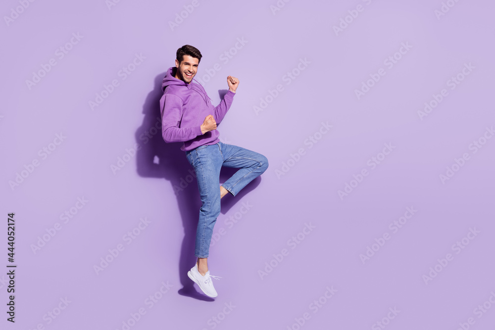 Full length body size view of attractive lucky cheerful guy jumping rejoicing great news isolated over purple violet color background Full length body size view of attractive lucky cheerful guy jumping rejoicing great news isolated over purple violet color background