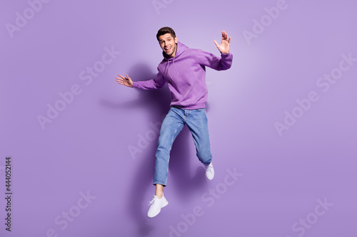 Full length body size photo man jumping up cheerful overjoyed isolated pastel purple color background photo