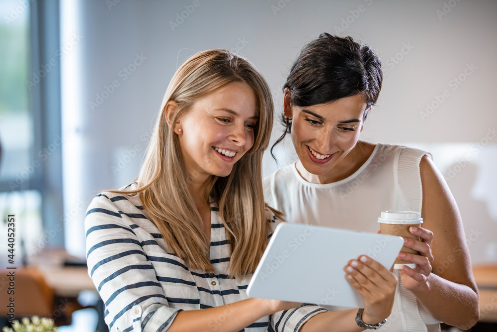 Attractive business partners discussing details of their mutually beneficial cooperation while having negotiations in cozy office. Twobusiness women working together in office Attractive business partners discussing details of their mutually beneficial cooperation while having negotiations in cozy office. Twobusiness women working together in office