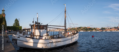 Old fishing boats at the Stockholm City Town Hall pier at sunset