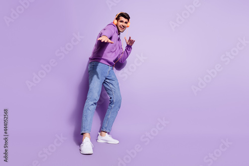 Full length body size photo man wearing headphones dancing isolated pastel purple color background