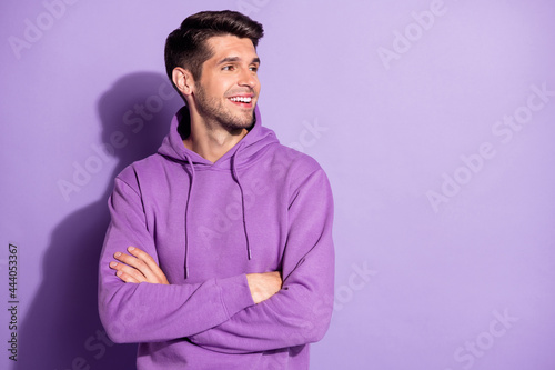 Portrait of attractive content cheerful guy folded arms looking aside copy space isolated over purple violet color background © deagreez