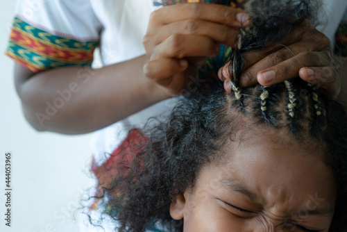 Photography Close up African hairstylist braided hair of afro little girl, young girl makes