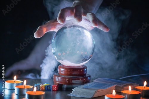 Magician or fortune teller is predicting future with crystal sphere. photo