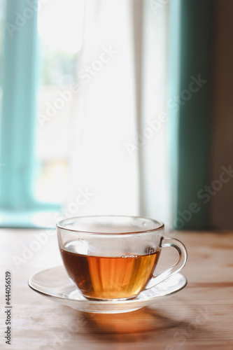a glass cup of tea on a wooden table