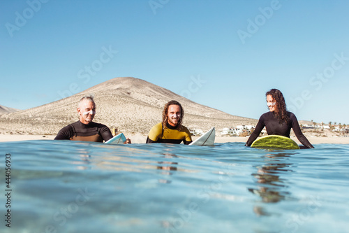 Three friends going to surf in the sea photo