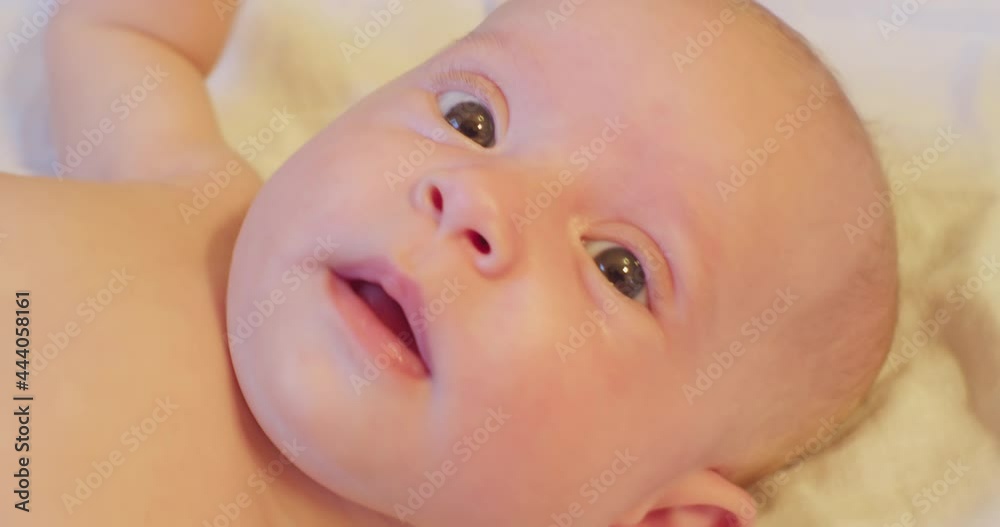 portrait of a small cute funny child who lies in his bed and looks up with surprise. close-up. portrait of a small cute funny child who lies in his bed and looks up with surprise. close-up.