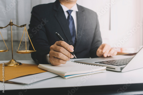 Business and lawyers discussing contract papers with brass scale on desk in office. Law, legal services, advice, justice and law concept picture with film grain effect