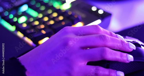 Close up of the hand of a gamer girl, moving the mouse while playing a pc game