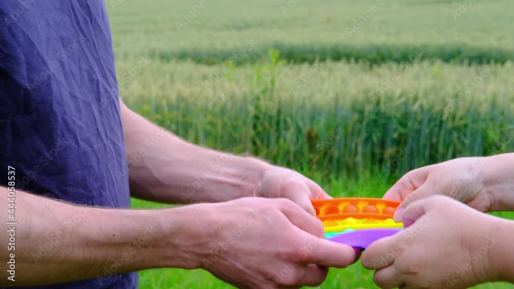 Toy Hand Remove female and male hands holding rainbow Toy antistress Pop it, poppit ...