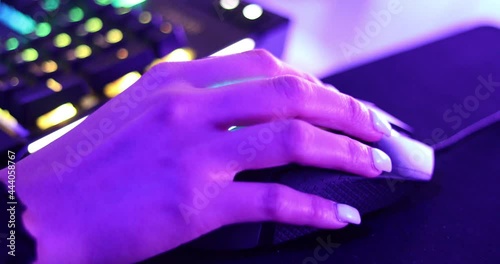 Close up of the hand of a gamer girl, moving the mouse while playing a pc game