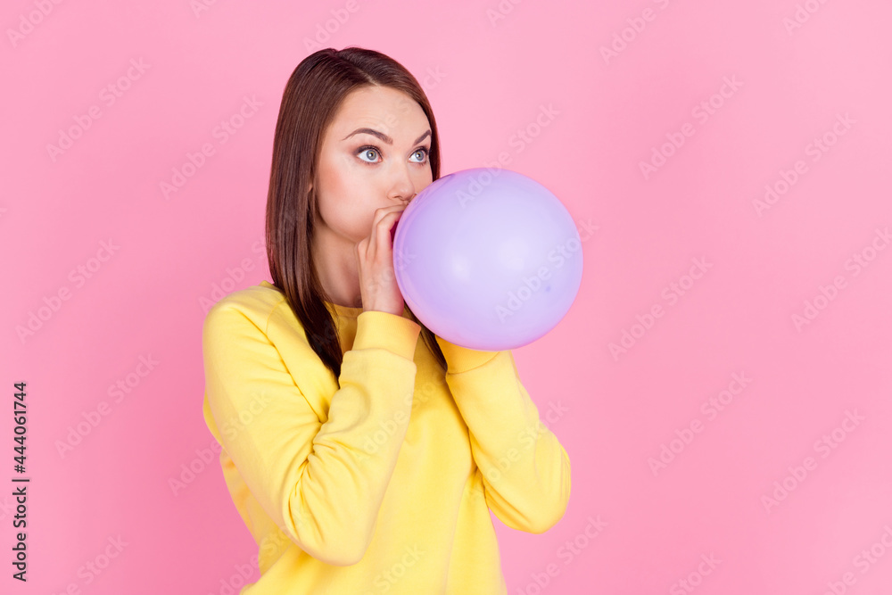 Photo portrait girl inflating purple air balloon preparing to party looking blank space isolated pastel pink color background Photo portrait girl inflating purple air balloon preparing to party looking blank space isolated pastel pink color background