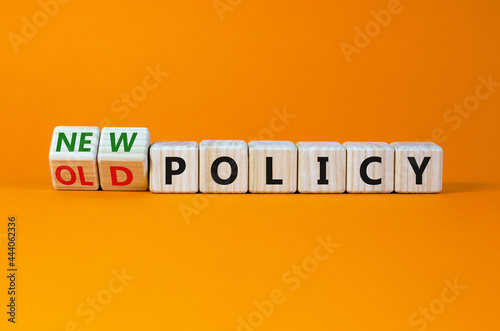 New or old policy symbol. Turned wooden cubes, changed words 'old policy' to 'new policy'. Beautiful orange table, orange background. Business, old or new policy concept. Copy space.