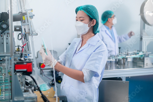 Workers producing surgical mask in modern factory, Covid-19 protection and medical concept. © tonefotografia