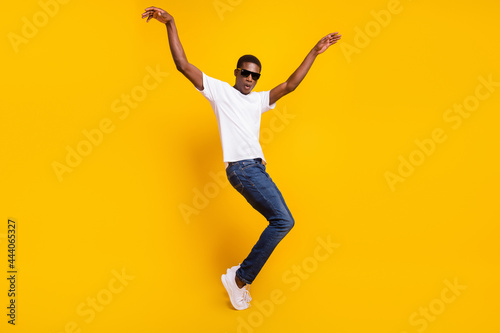 Full length body size view of attractive funky carefree guy dancing having fun good mood isolated over bright yellow color background