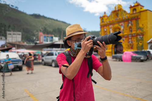 Man taking photos with his professional camera in the plaza of San Andrés Xecul, Guatemala. photo