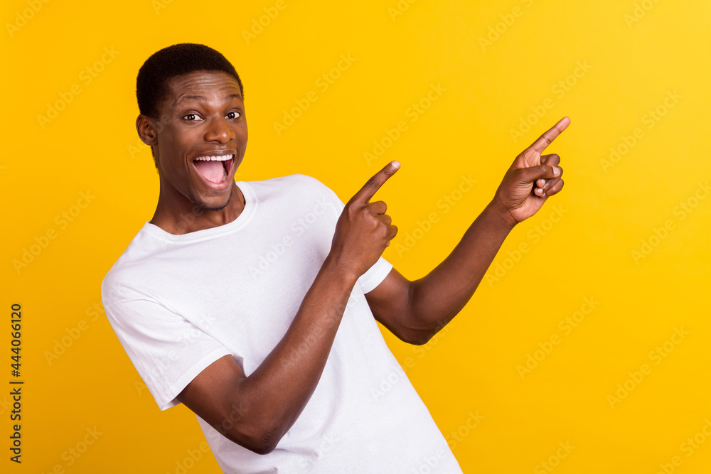Portrait of attractive amazed cheerful guy demonstrating ad offer bargain isolated over bright yellow color background