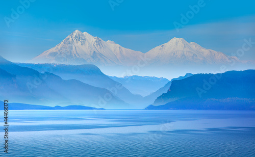 Amazing blue mountains over the blue seav with gorgeous blue sky in the background © muratart