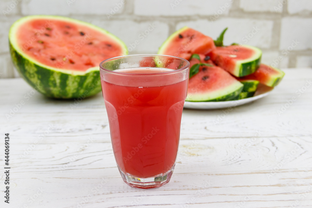 Glass of fresh watermelon juice on a white wooden table Glass of fresh watermelon juice on a white wooden table