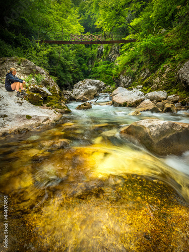 A tourist relaxing at Tolmin Gorge (Tolminska Korita), Soca Valley, Triglav National Park, Slovenia, Europe