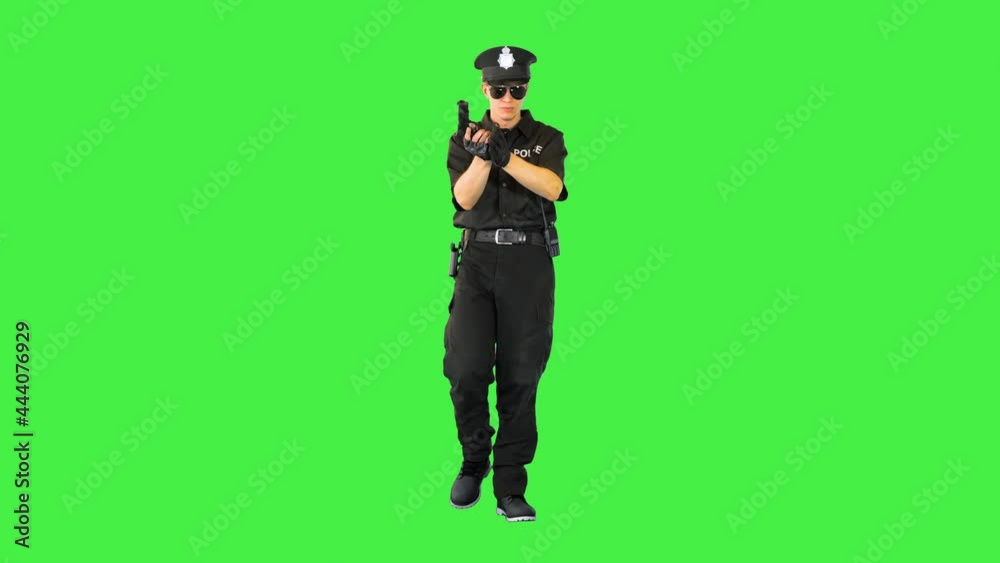 Policeman walks doing some exercices with his gun on a Green Screen, Chroma Key. Policeman walks doing some exercices with his gun on a Green Screen, Chroma Key.