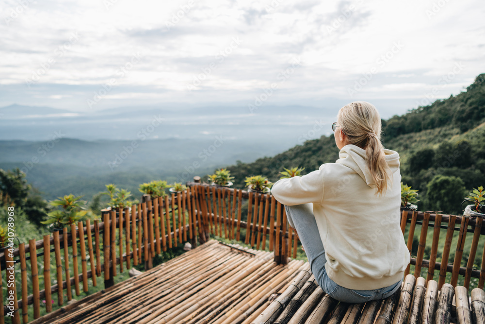 Woman is sitting at viewpoint in strawberry field in Thailand