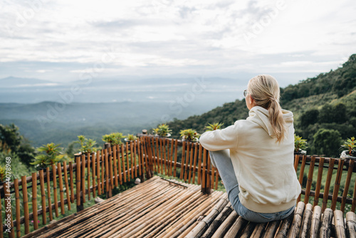Woman is sitting at viewpoint in strawberry field in Thailand photo