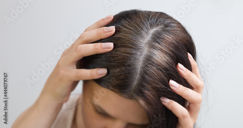Close up are fragments of gray hair on the head of a young woman. Early gray hair concept. Gray hair color and structure
