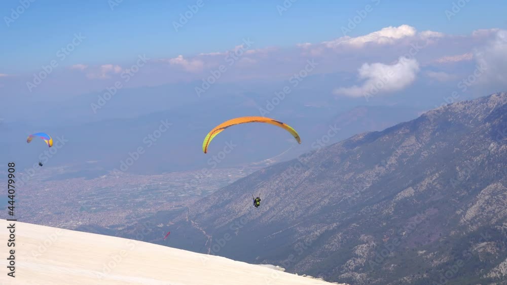Paraglider soaring on paragliding in the sky in mountain. Extreme sport in mountains Paraglider soaring on paragliding in the sky in mountain. Extreme sport in mountains