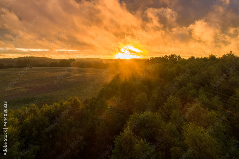 Fields, meadows and forests with a beautiful sunset. Polish countryside in amazing nature conditions and beautiful light. Orange sun and cloudy forest. Fields, meadows and forests with a beautiful sunset. Polish countryside in amazing nature conditions and beautiful light. Orange sun and cloudy forest.