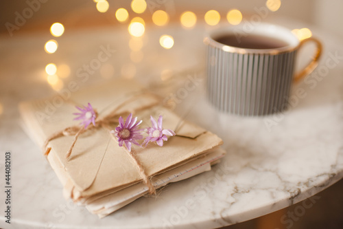 Obraz na płótnie Romantic paper letters with dry flowers and cup of coffee over glowing lights at background close up