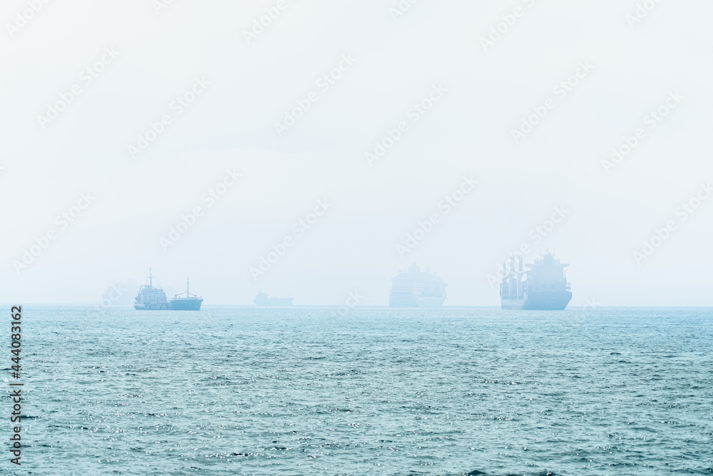 Large container ships and cruise liners in morning haze near Limassol, Cyprus