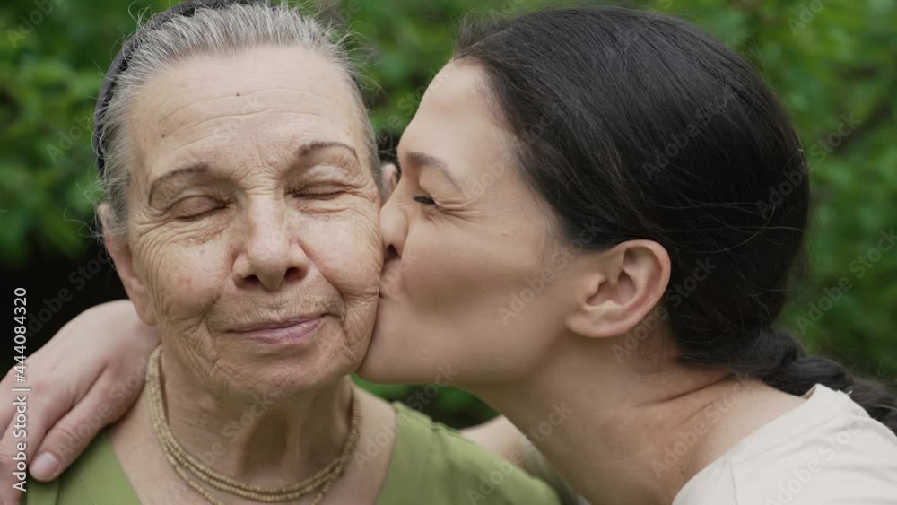 Granddaughter kissing grandmother on the cheek Granddaughter kissing grandmother on the cheek