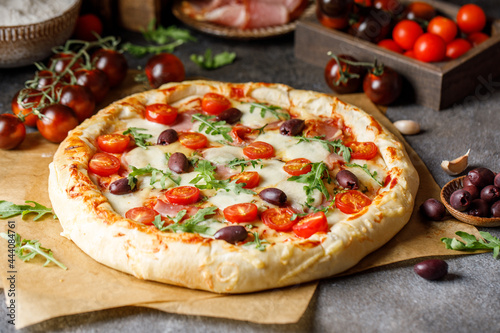 Italian pizza: tomato paste, mozzarella, parma ham, arugula, olives, cherry tomatoes. Ingredients for cooking. Italian pizza with arugula