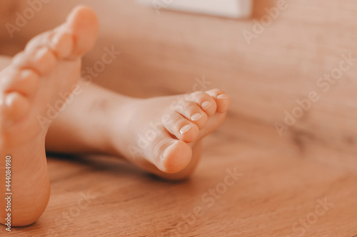 Feet of a small child on a solid wooden background, toes photo
