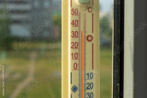 Outdoors thermometer on the window shows a abnormal hot temperature outside