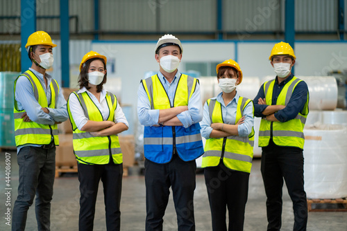 Group of warehouse worker stand in row with confidence or arm crossed action in workplace area. Main focus on man in center of image.