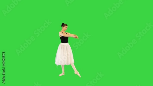 Young ballerina performing basic movements on a Green Screen, Chroma Key. photo