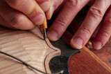 Luthier is working on details of violin body