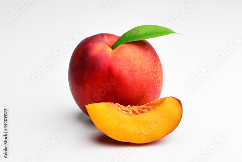 Nectarine peaches with slice and leaf isolated on white background. Fresh peach leaf isolated on white. Organic peach. Peach clipping path. Full depth of field. 
