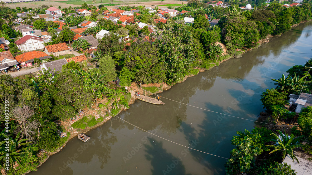 Aerial view of Boat sledding to cross the river. Bekasi, Indonesia, July 9, 2021 Aerial view of Boat sledding to cross the river. Bekasi, Indonesia, July 9, 2021