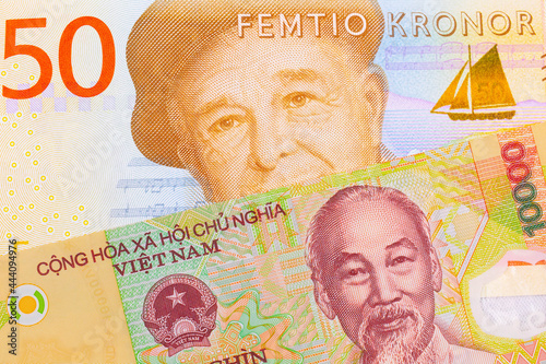 A macro image of a gray and orange fifty kronor note from Sweden paired up with a colorful, plastic ten thousand dong note from Vietnam.  Shot close up in macro.