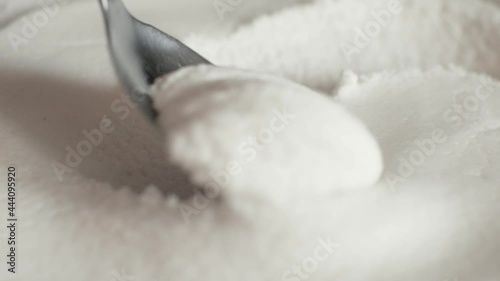 Ice cream is taken with a spoon close up