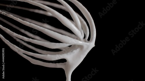 Yogurt whipped with a mixer flows down from the whisk