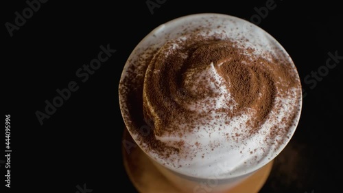 Coffee with whipped cream is sprinkled with chocolate crumbs close up