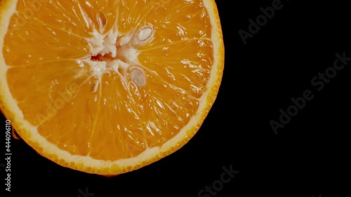 The orange is watered with water from above close up